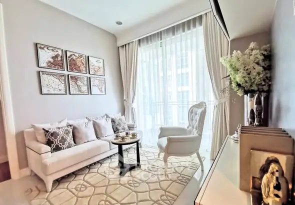 Elegant living room with plush sofa, armchair, and large window for natural light.