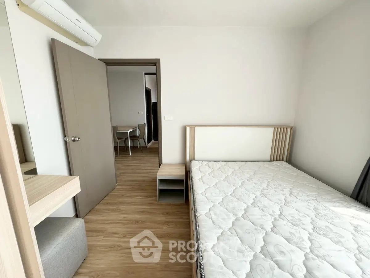 Modern minimalist bedroom with wooden flooring and neutral tones