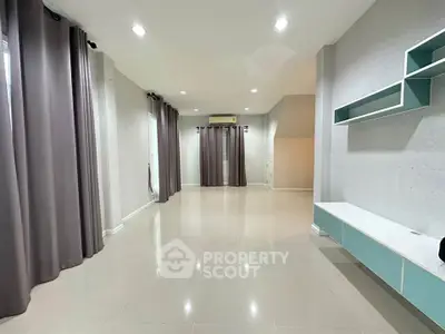 Spacious modern living room with sleek design and ample natural light.