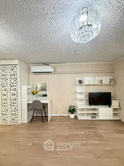 Spacious living room with modern decor and elegant lighting, featuring a cozy workspace and entertainment area.