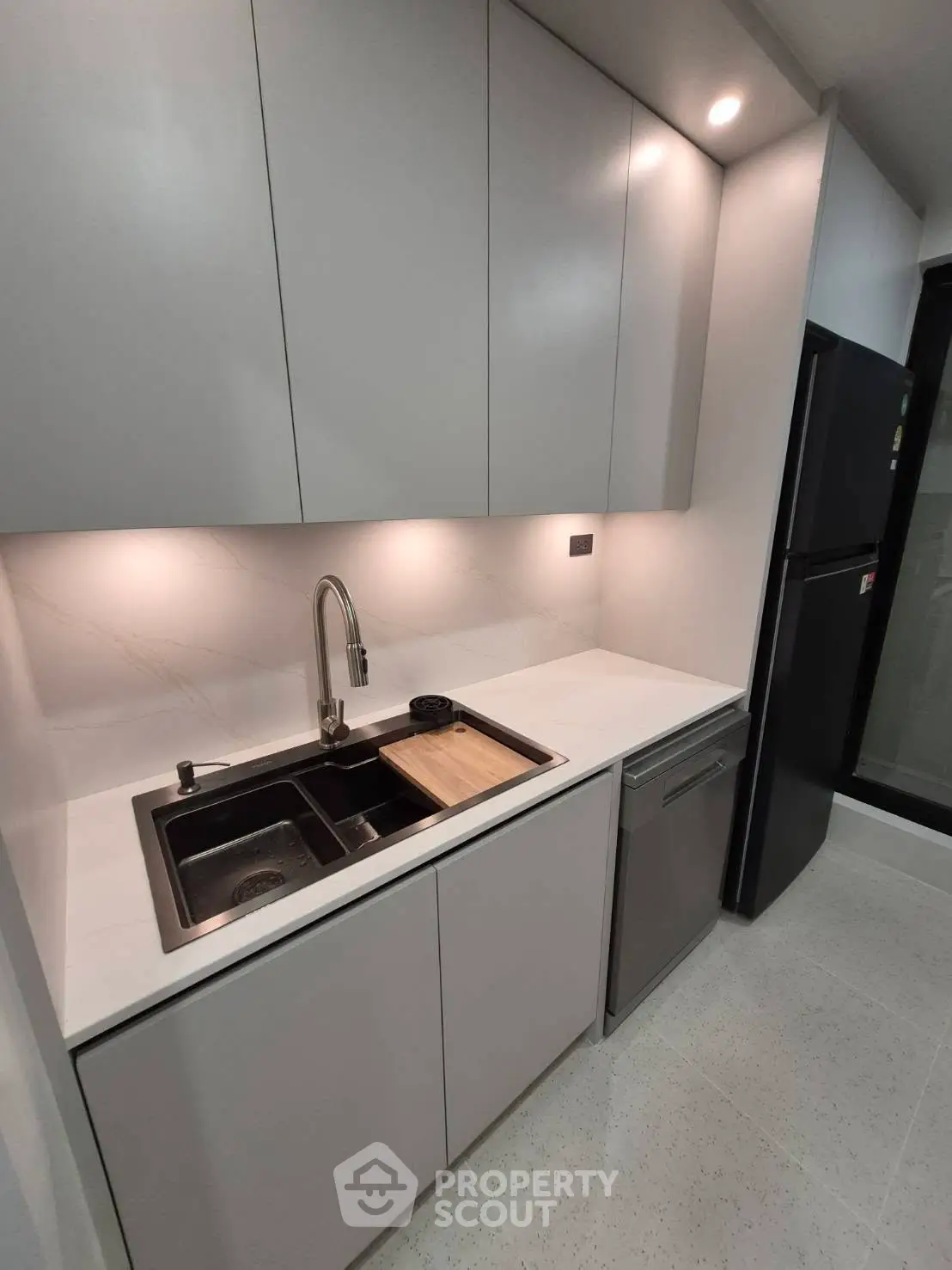 Modern kitchen with sleek cabinetry and built-in appliances, featuring a stylish sink and contemporary design.