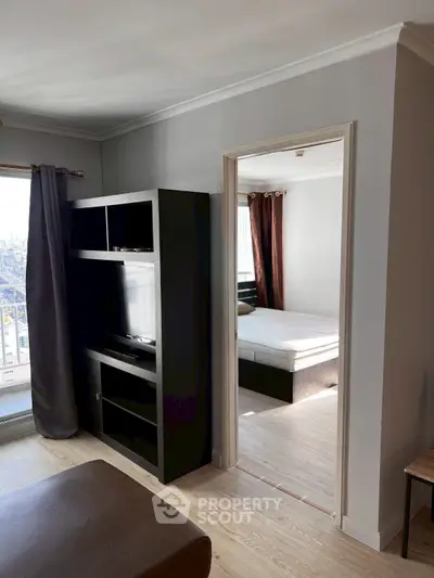 Modern apartment interior with sleek living room and cozy bedroom, featuring large windows and stylish furnishings.