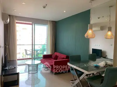 Modern living room with vibrant red sofa and dining area, featuring large windows and stylish lighting.