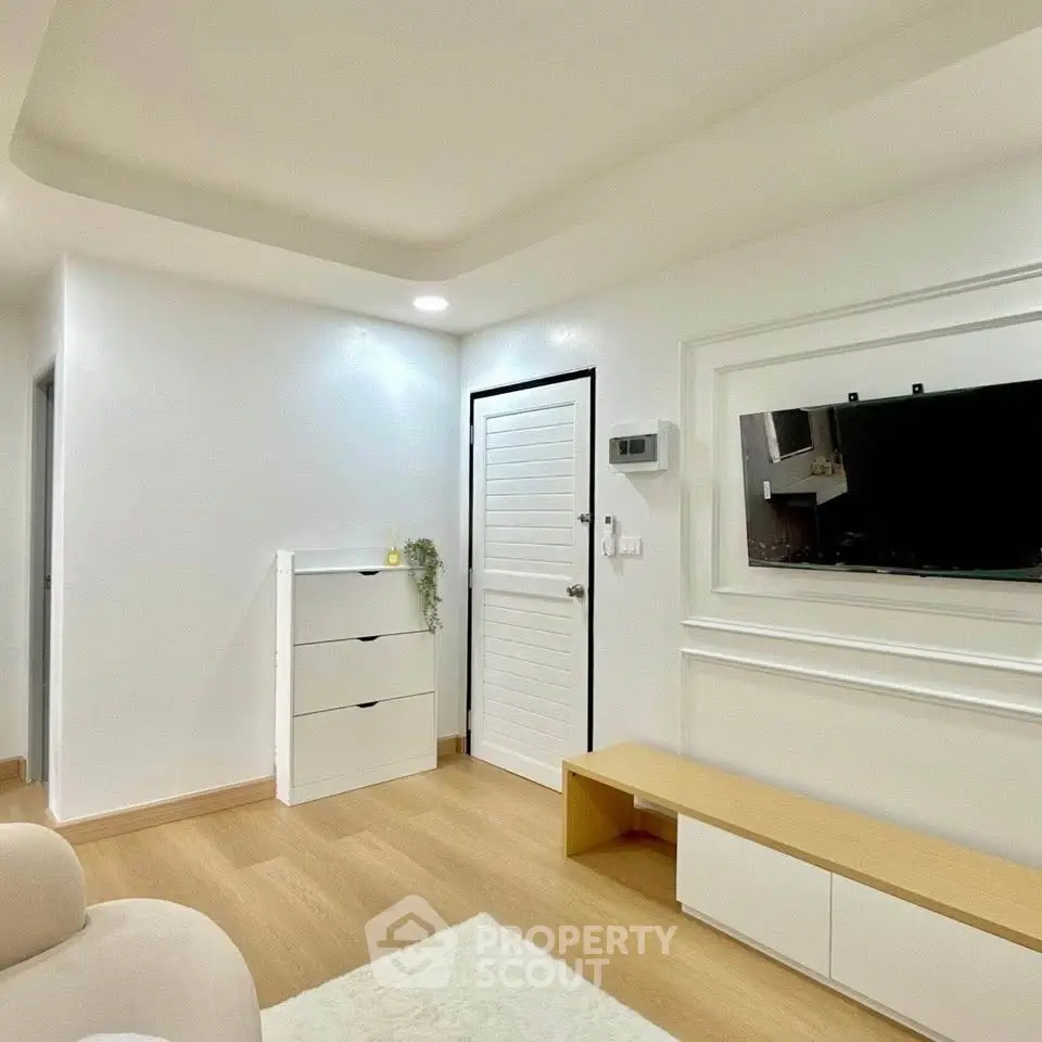 Modern minimalist living room with sleek white furniture and wooden flooring