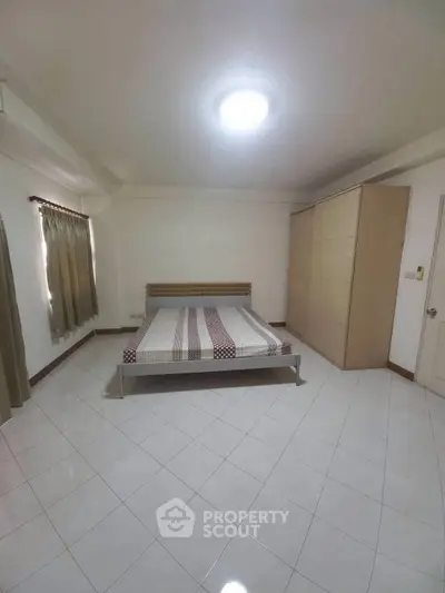 Spacious bedroom with minimalist design and ample natural light