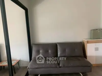 Modern living room with sleek black leather sofa and large mirror