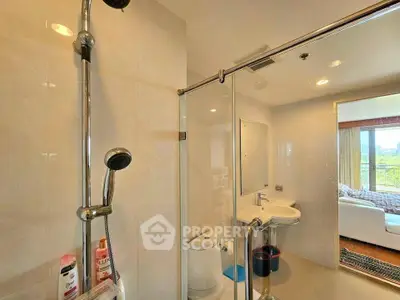 Modern bathroom with glass shower and sleek fixtures in a contemporary apartment.