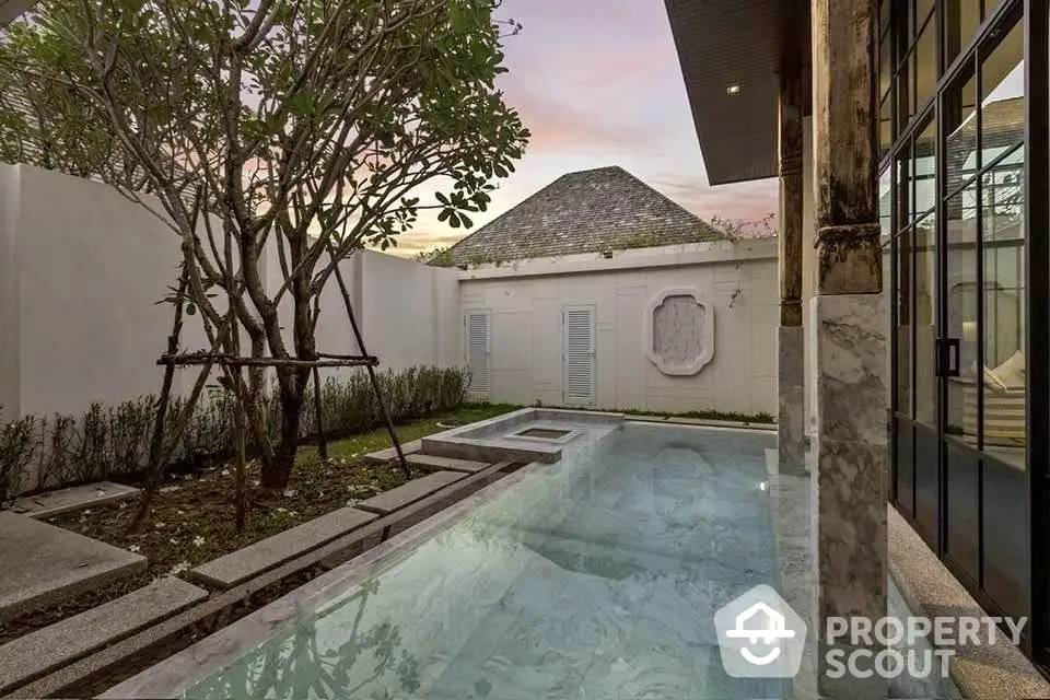 Luxurious private pool with elegant landscaping and modern architecture at sunset.