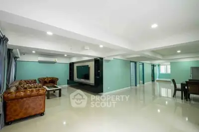 Spacious modern living room with elegant leather sofas and large TV unit
