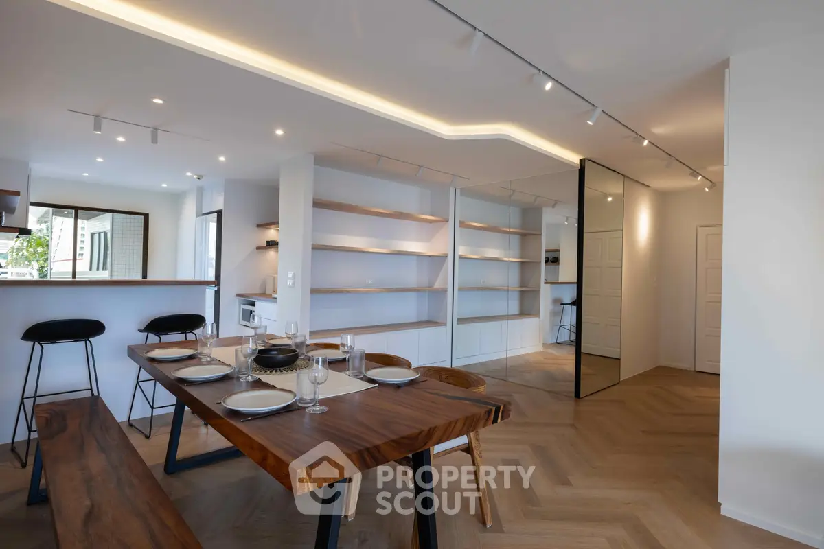 Modern dining area with stylish wooden table and open kitchen layout