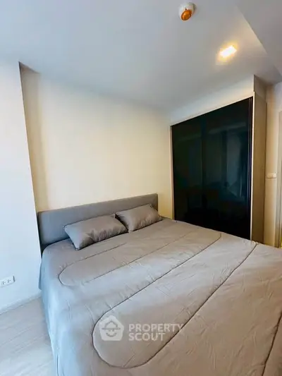 Modern bedroom with sleek design and cozy bedding in a stylish apartment.