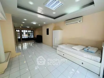 Spacious modern living room with sleek white tiles and air conditioning, perfect for comfortable living.