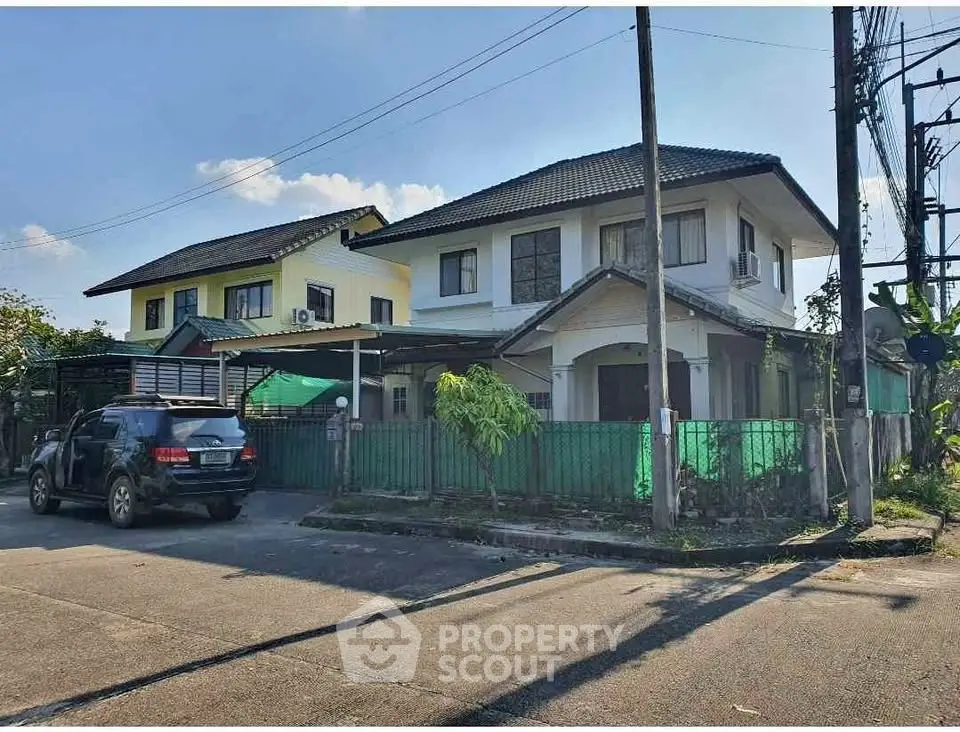 Charming suburban house with spacious driveway and lush greenery, perfect family home in a serene neighborhood.
