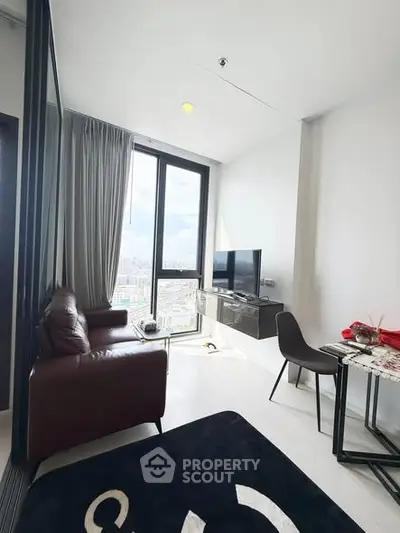 Modern living room with city view, featuring sleek furniture and large windows for natural light.