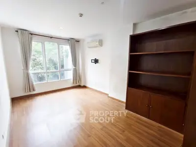 Spacious empty room with wooden flooring and large window view