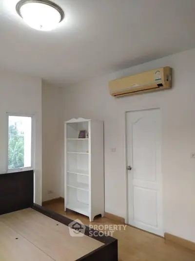 Bright bedroom with air conditioning and white shelving unit
