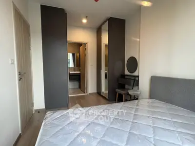 Modern bedroom with stylish furniture and ensuite bathroom in a contemporary apartment.
