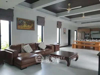 Spacious modern living room with elegant furniture and open kitchen layout, perfect for family gatherings.