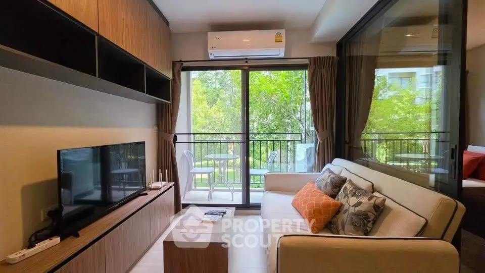 Modern living room with balcony view, stylish furniture, and natural light.