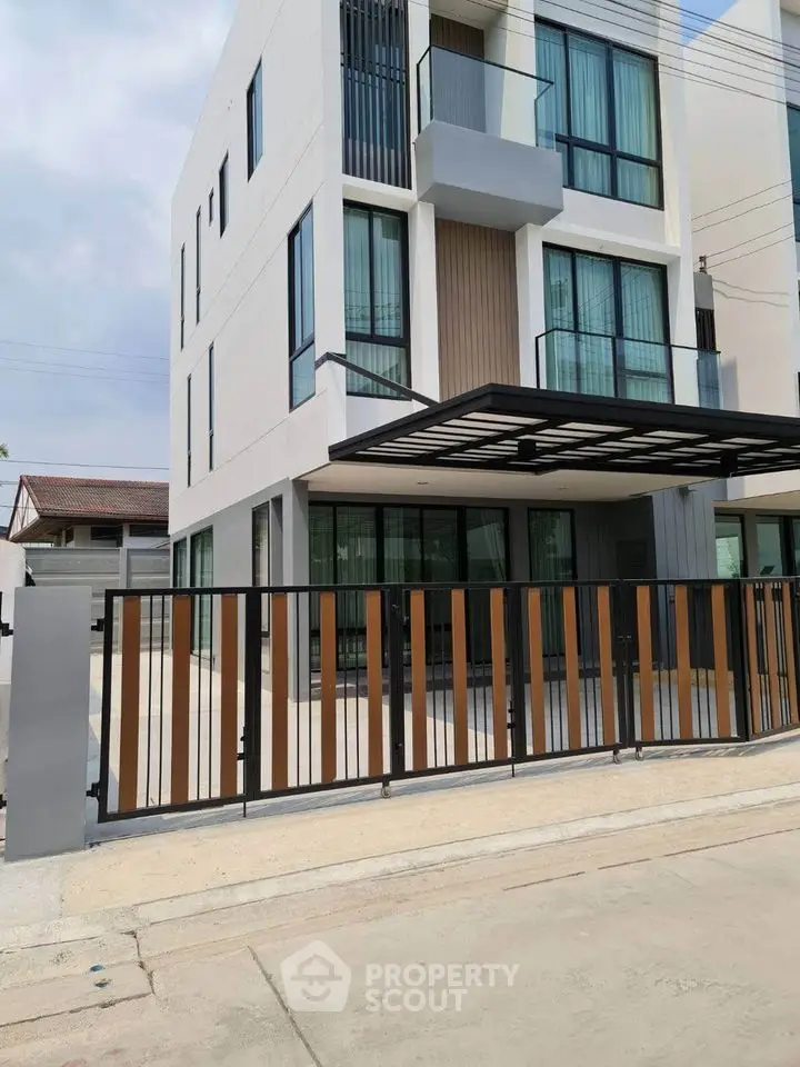 Modern three-story building with sleek design and gated entrance