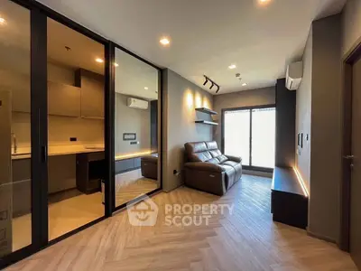 Modern living room with sleek design and glass partition, featuring cozy seating and ambient lighting.