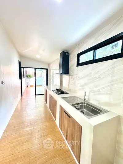 Modern kitchen with sleek design and open layout, featuring a gas stove and ample natural light.