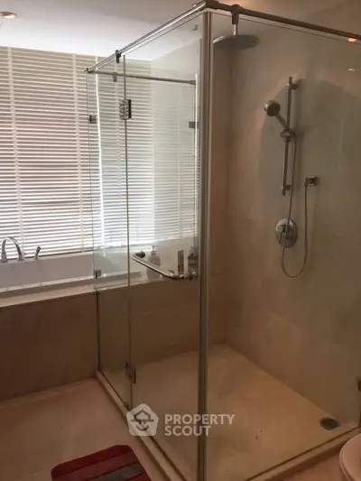Luxurious bathroom with glass shower and bathtub, featuring modern fixtures and elegant design.