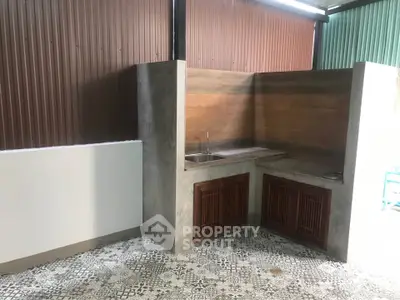 Charming outdoor kitchen with rustic design and patterned tile flooring.