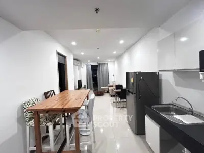 Modern open-layout kitchen and living area with sleek design and ample natural light.