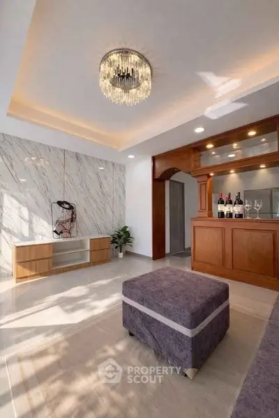 Elegant living room with modern chandelier and stylish bar area, perfect for entertaining guests.