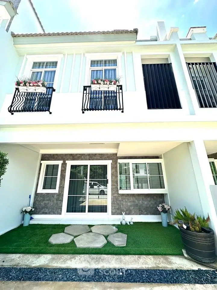 Charming two-story townhouse with elegant facade and small landscaped garden