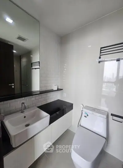 Modern bathroom with sleek fixtures and city view window.