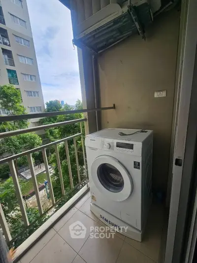 Compact balcony with washing machine in urban apartment setting
