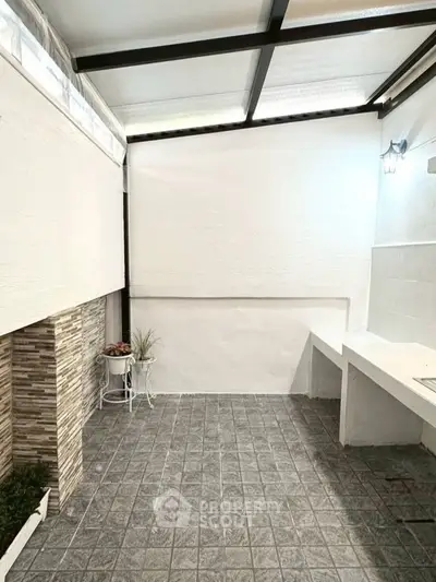 Charming outdoor patio with tiled flooring and modern lighting, perfect for relaxation and entertaining.