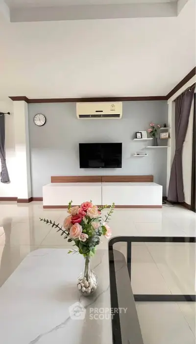 Modern living room with sleek TV unit, air conditioning, and elegant decor, perfect for contemporary living.