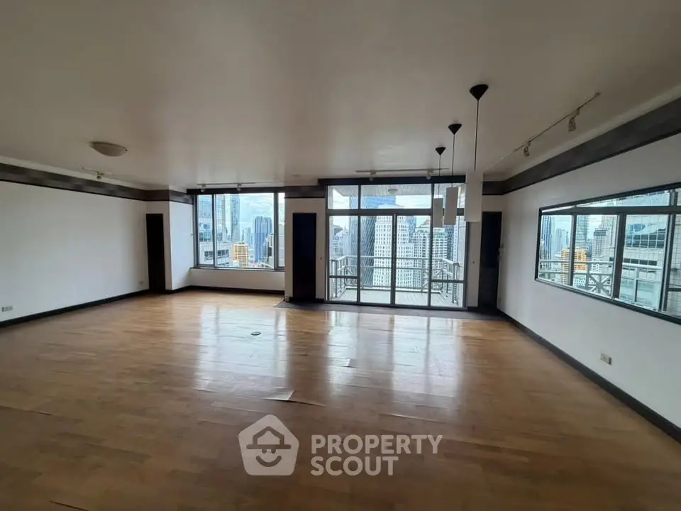 Spacious living room with large windows offering stunning city views in a modern apartment.