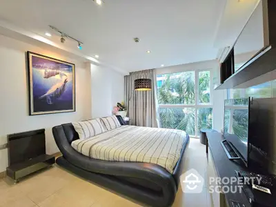 Luxurious bedroom with modern decor and large windows offering a serene view of lush greenery.