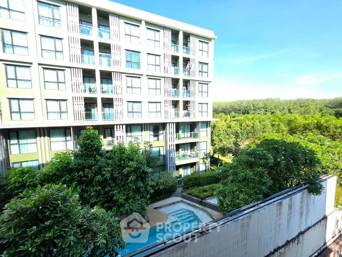 Modern condominium building with lush greenery and pool view