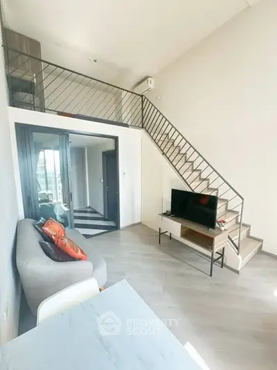 Modern loft apartment with stylish staircase and cozy living area, perfect for urban living.