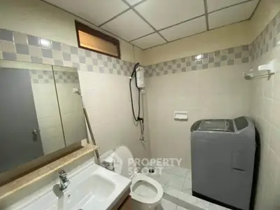 Compact bathroom with washing machine and shower in modern apartment