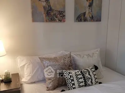 Cozy bedroom with stylish decor and elegant artwork above the bed.