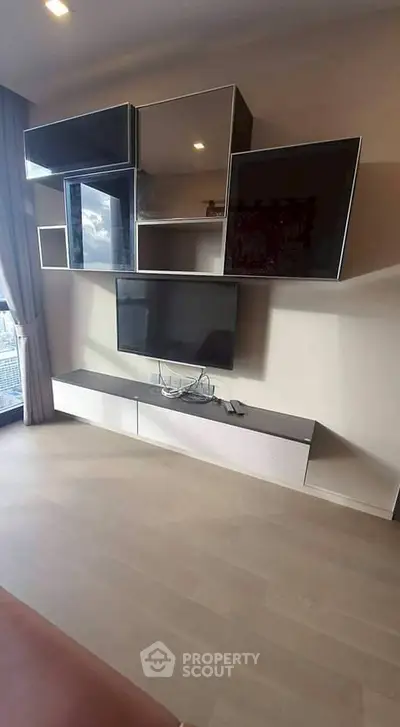 Modern living room with stylish wall-mounted TV and sleek storage units