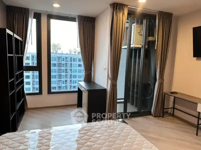 Modern bedroom with large windows and balcony view in urban apartment