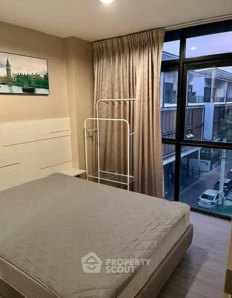 Cozy bedroom with large window and modern decor in urban apartment