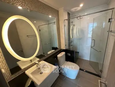 Modern bathroom with glass shower and illuminated mirror