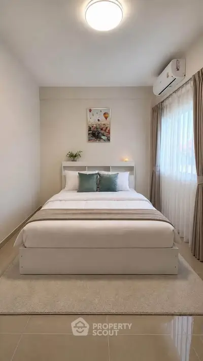 Modern bedroom with cozy decor and natural light, featuring a stylish bed and elegant curtains.