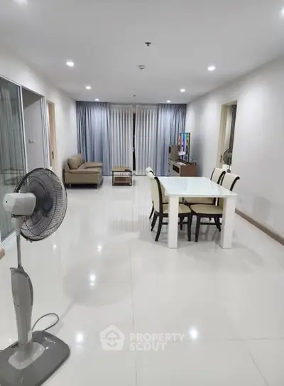 Spacious modern living room with dining area and sleek furnishings in a bright, open layout.