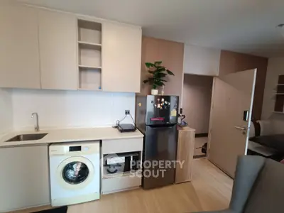 Modern kitchen with washing machine and fridge in compact apartment