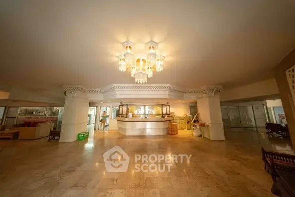 Spacious hotel lobby with elegant chandelier and marble flooring