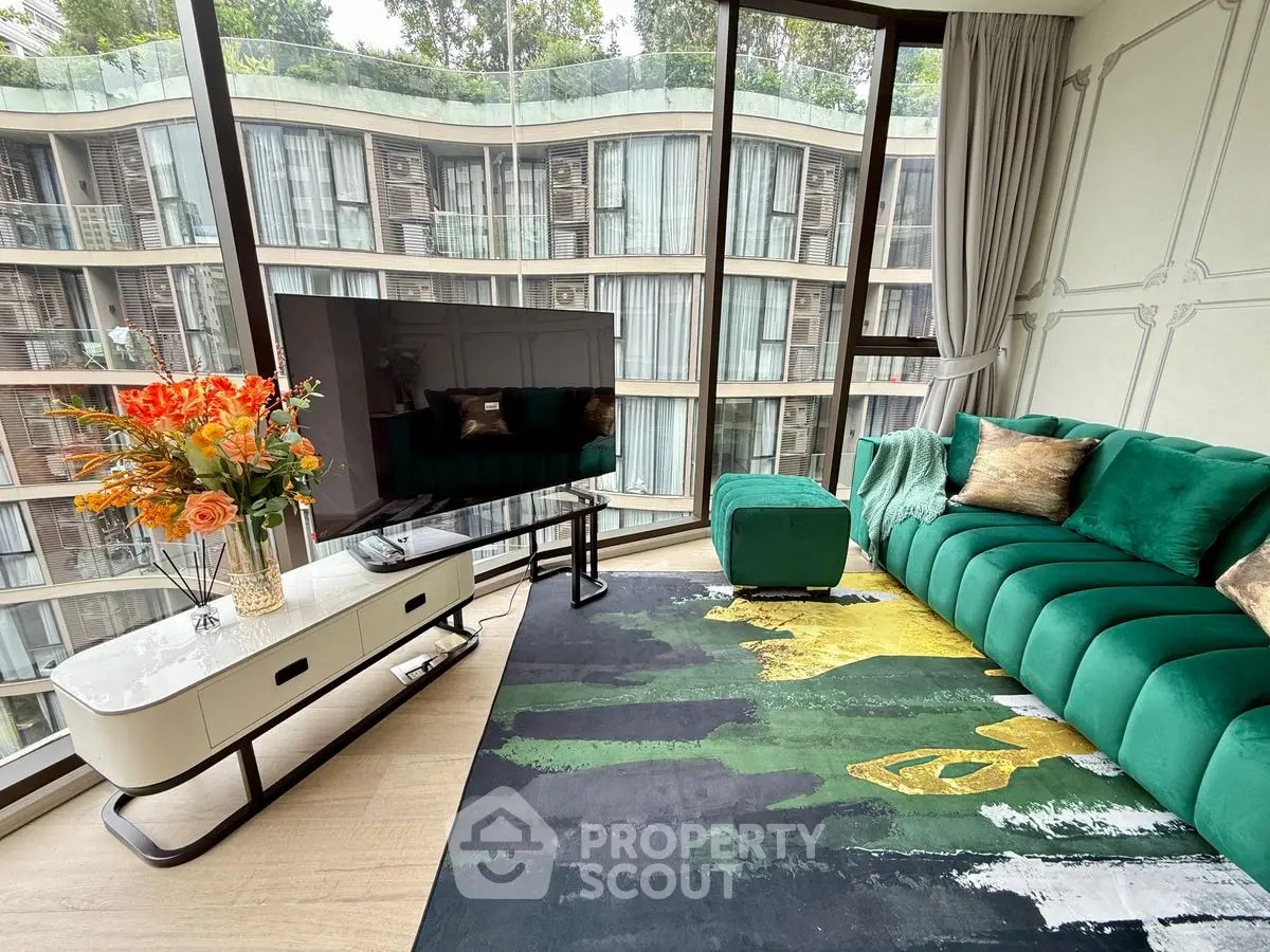 Luxurious living room with modern green sofa and large TV, offering stunning city views through floor-to-ceiling windows.